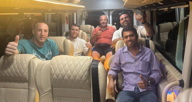 Several people sitting inside a vehicle giving thumbs-up.