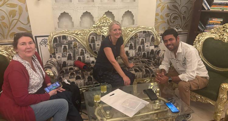 Three people sitting around a glass table.