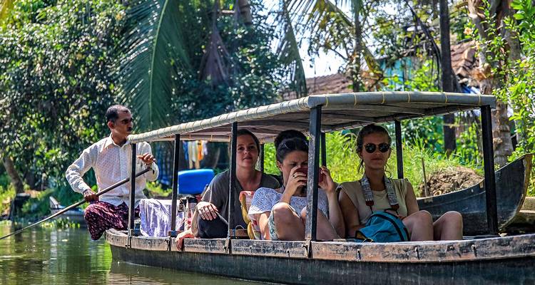 Un groupe de touristes profitant d'une promenade en bateau à travers une végétation luxuriante.