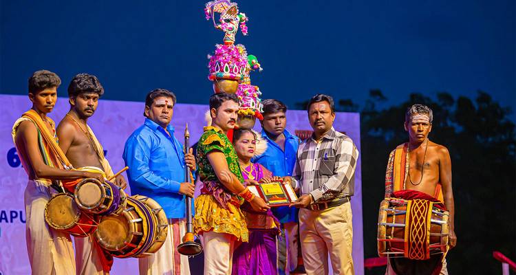 Des artistes en tenue traditionnelle sur scène lors d'un événement culturel.