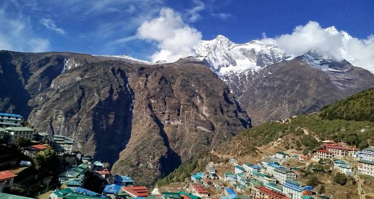 Village niché dans une vallée avec des montagnes enneigées.