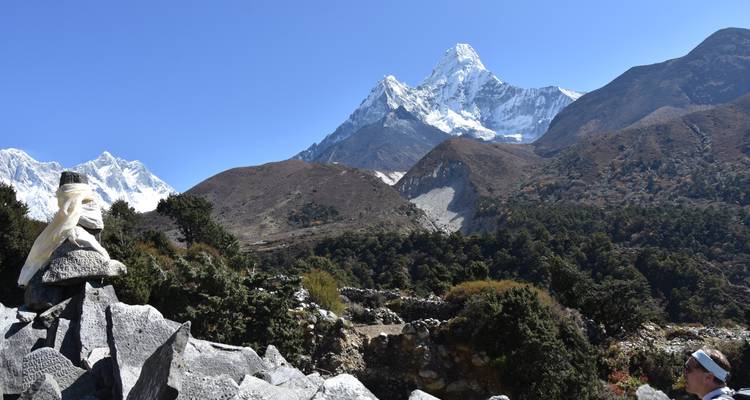 Uitzicht op besneeuwde bergtoppen met rotsachtige voorgrond.