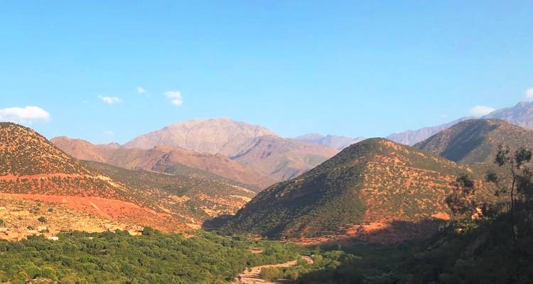 Une vue pittoresque de vallées verdoyantes avec des montagnes escarpées en arrière-plan.