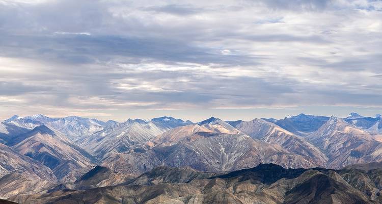 Ausgedehnte Bergkette unter bewölktem Himmel.