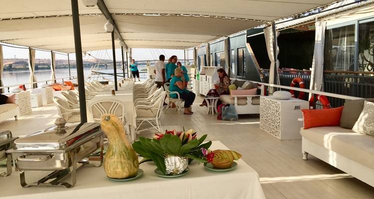 Mensen die zitten op een comfortabel openlucht cruisedek met decoratieve planten.