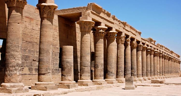 Oud-Egyptische tempel met rijen zuilen onder een heldere blauwe hemel.