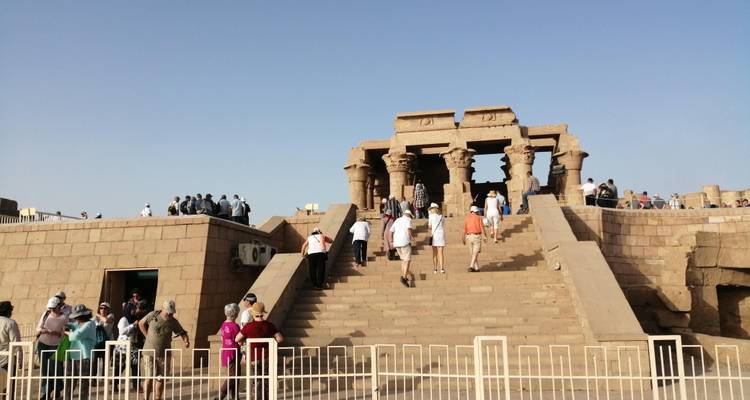 Mensen die een oude tempel bezoeken met massieve zuilen en stenen constructies.