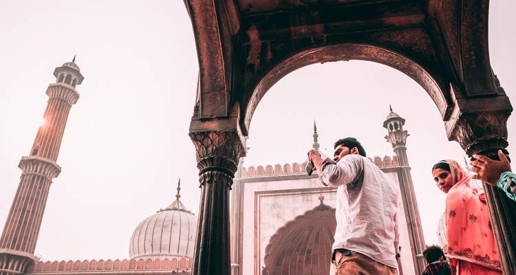 Des gens prennent des photos dans une mosquée historique à l'architecture décorative.