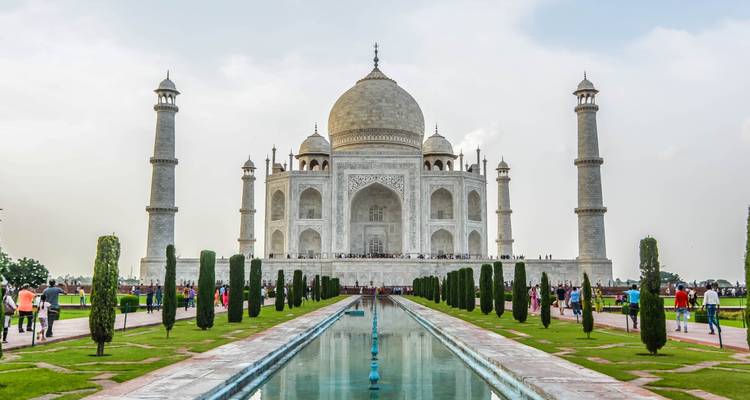 Célèbre mausolée en marbre blanc entouré de jardins avec des visiteurs.