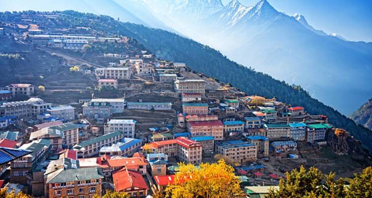 Bunte Stadt eingebettet in einem Tal mit Bergkulisse.