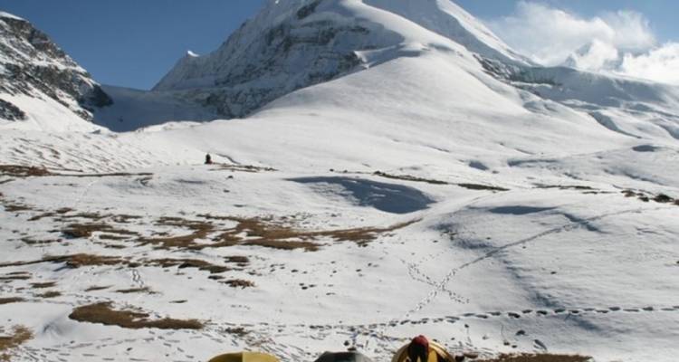 Tenten opgezet op een besneeuwd landschap nabij een bergtop.