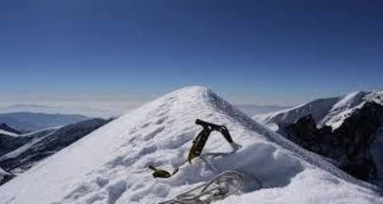 Berggipfel mit schneebedeckter Landschaft und klarem Himmel.