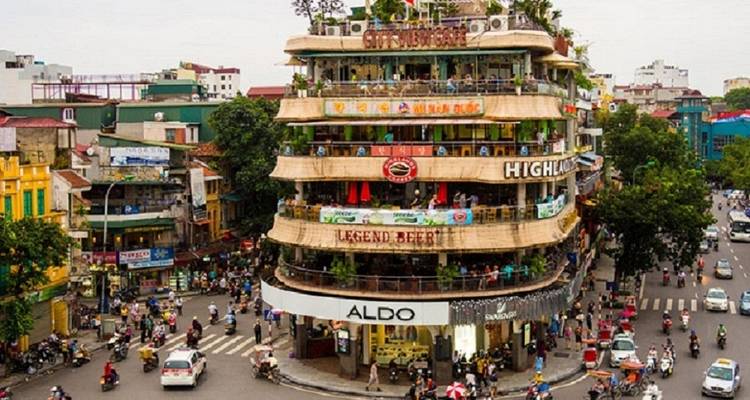 Rue animée avec un bâtiment de café à plusieurs étages.