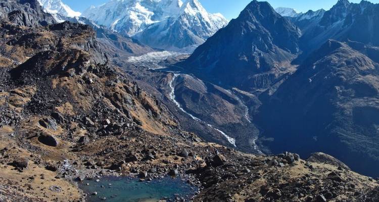 Malerische Aussicht auf schneebedeckte Berge mit rauer Landschaft und einem kleinen Teich.
