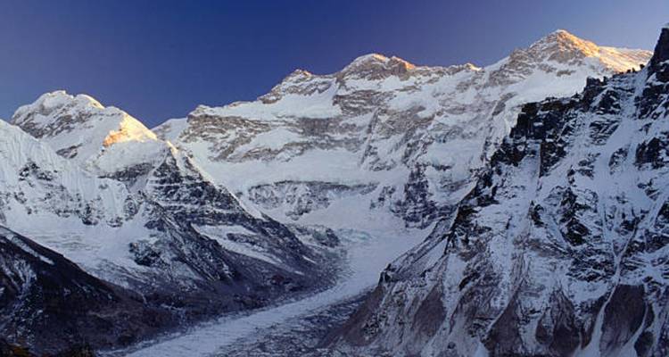Panoramablick auf schneebedeckte Berge mit einem Gletscher im Tal.