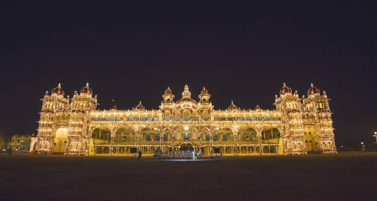 Het Mysuru Paleis verlicht met lichten in de nacht.