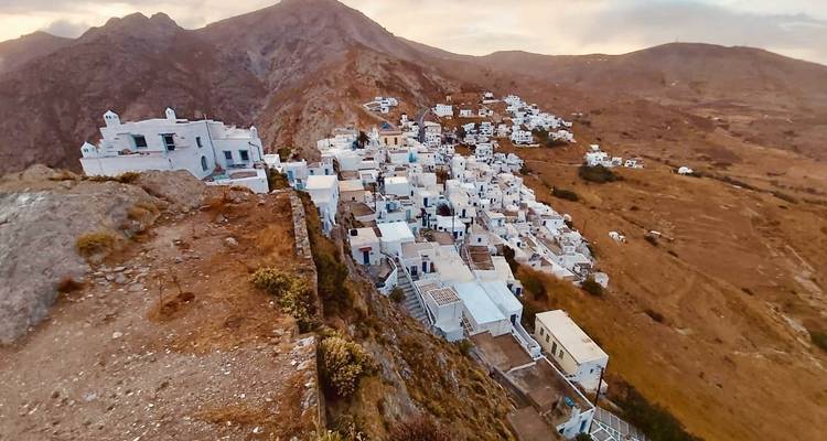 Griekse stad op een heuvel met witte huizen.