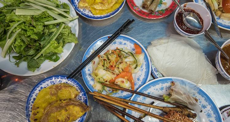 Variété de plats vietnamiens sur une table avec des baguettes.