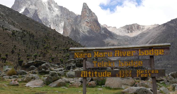 Bord met de tekst 'Naro Moru River Lodge' met een berg op de achtergrond.