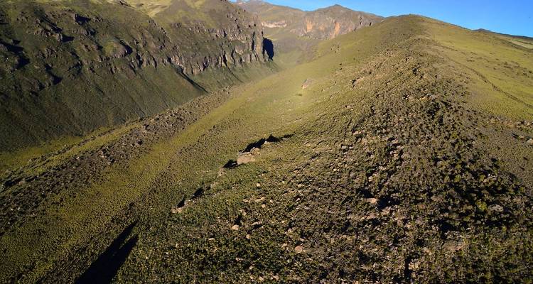 Groen bergachtig landschap met zichtbare bergkammen.
