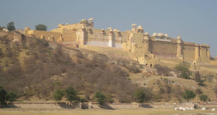 Fort historique sur une colline avec de hauts murs et un paysage aride.