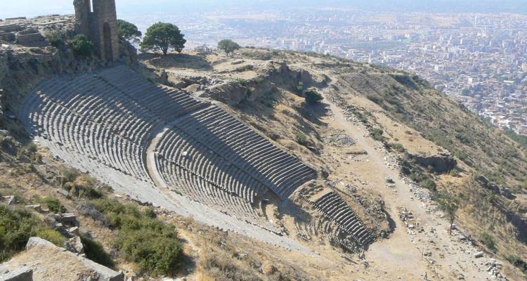 Antike Ruinen eines Theaters an einem Hang.