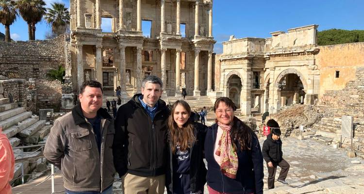 Group of people posing in front of ancient ruins.