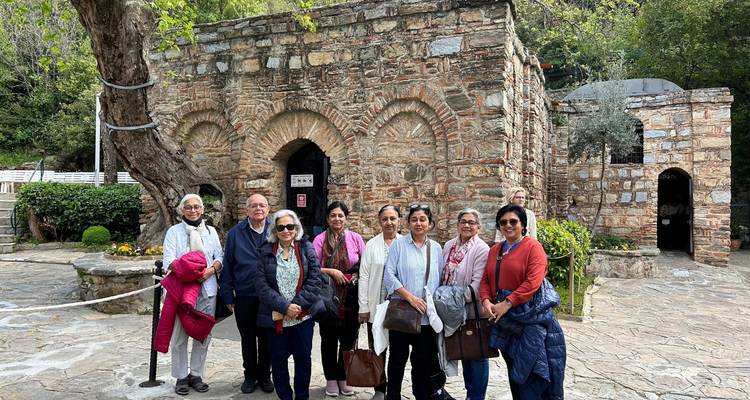 Group photo outside a historical stone house with arches.