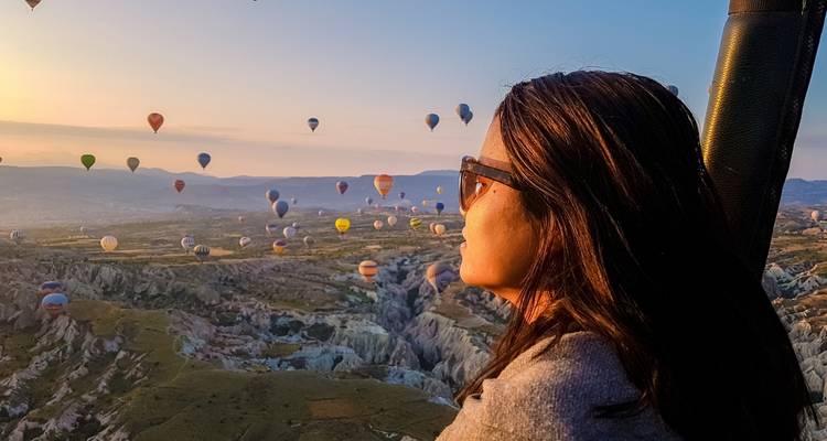 Person enjoying hot air balloons over unique landscape.