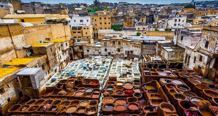 View of ancient buildings with dye pits in front.