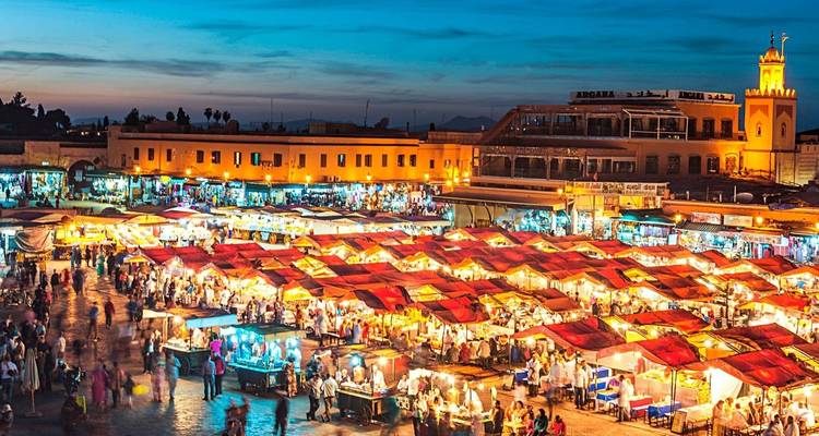 Vibrant evening market scene with people and colorful stalls