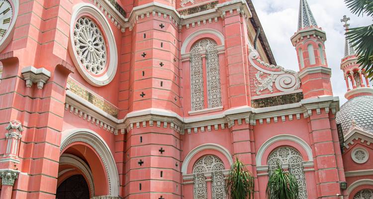 Nahaufnahme der rosa neoromanischen Fassade der Tan Dinh Kirche mit detaillierten weißen Steinmetzarbeiten in Ho-Chi-Minh-Stadt.