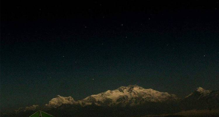 Sneeuwbedekte bergen onder een sterrenhemel.