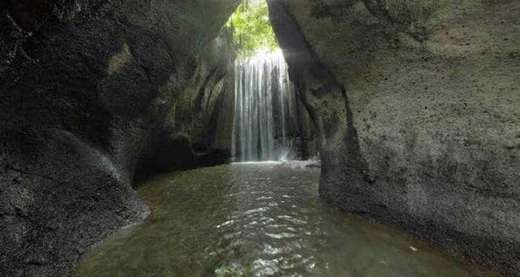 A secluded waterfall inside a rocky cavern.