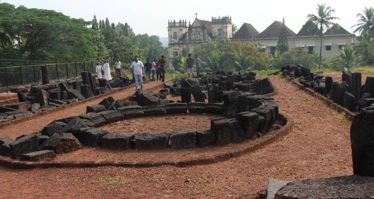 Des gens explorant des ruines avec une église historique en arrière-plan.