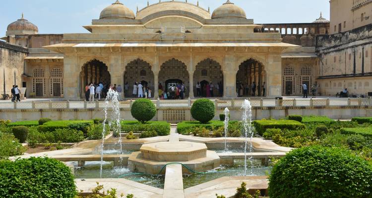 Ein Garten mit Springbrunnen vor einem historischen Pavillon.