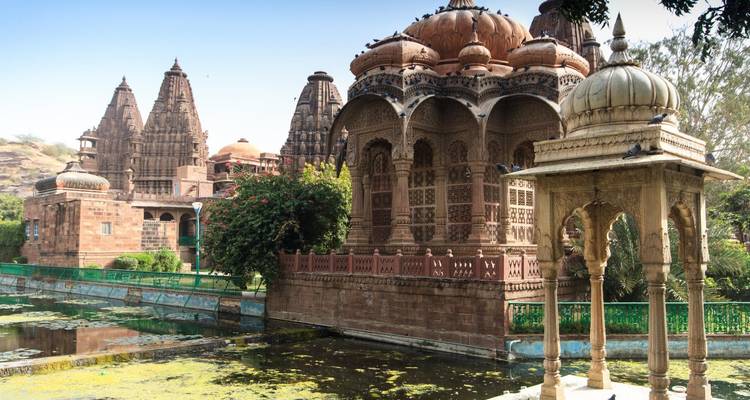 Temple complex with green pond and lush surroundings.