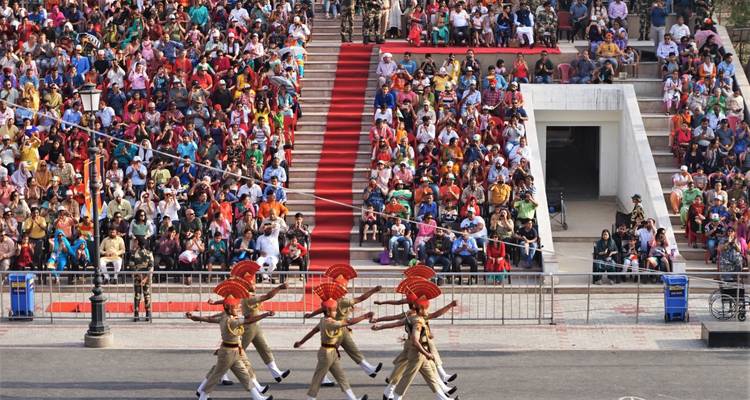 A parade with uniformed soldiers and a seated audience.