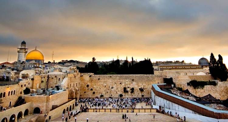 Klagemauer-Platz voller Gläubiger unter einem dramatischen bewölkten Sonnenuntergangshimmel in Jerusalem.