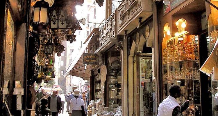 Belebte enge Gasse von Kairos Khan el-Khalili-Basar voller hängender Lampen und Einkäufer.