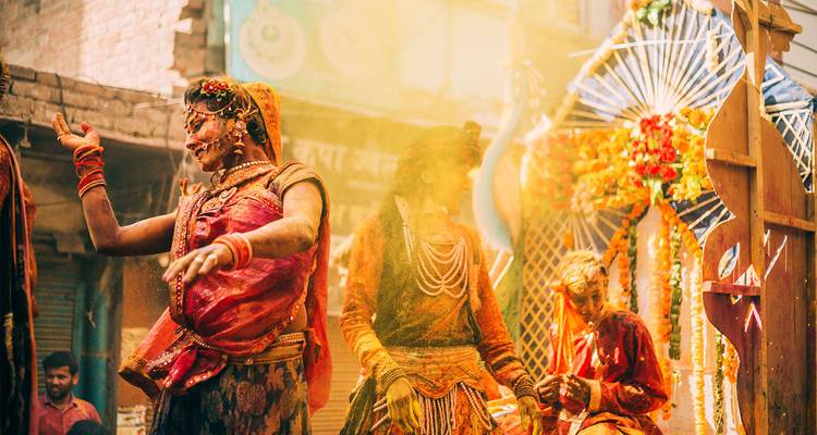Scène de festival traditionnel avec des personnes recouvertes de couleurs.
