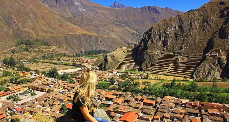 Persoon die het uitzicht op een oude citadel en terrassen bewondert.