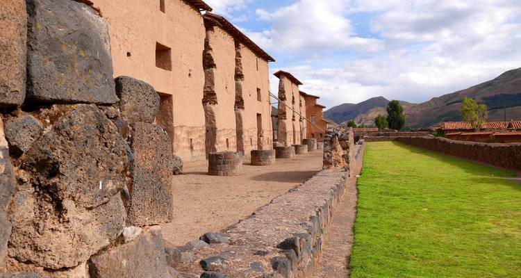 Ruïnes van oude stenen bouwwerken met een bergachtige achtergrond.