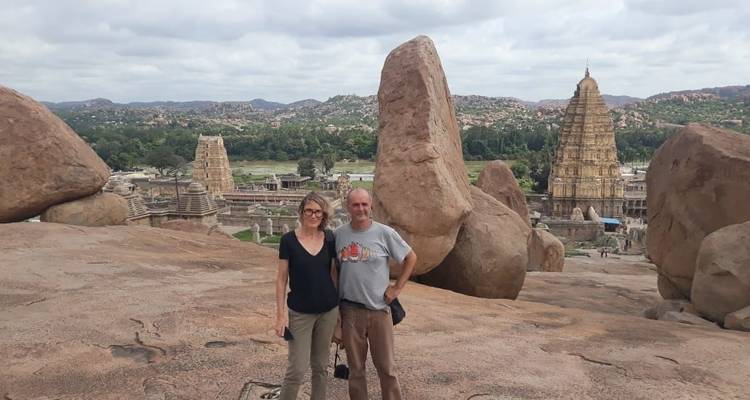 Two people with a view of an ancient temple complex.
