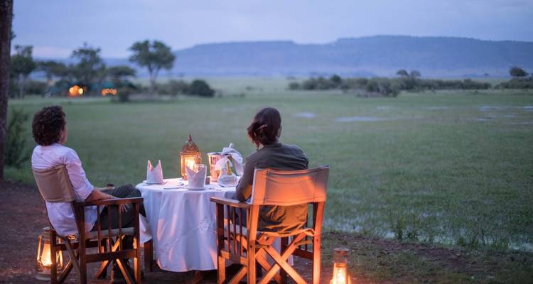 Een stel dat buiten dineert met uitzicht op open vlaktes.