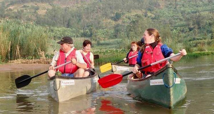Menschen, die in Kanus auf einem Fluss fahren und Schwimmwesten tragen.