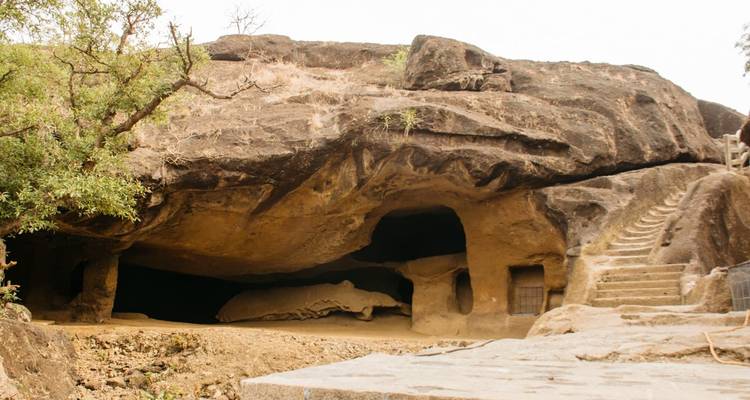 Rock-cut cave entrance with stairs leading inside.