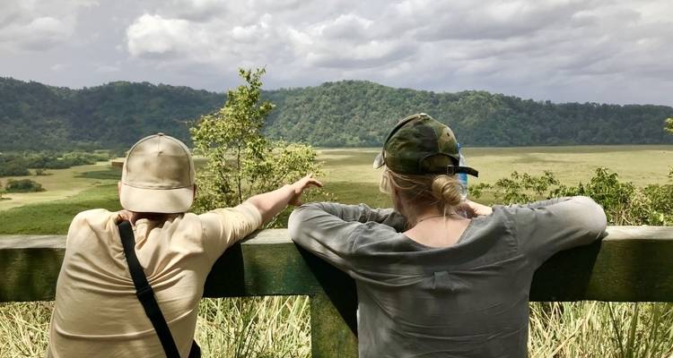 Deux personnes observant une vue panoramique depuis un point d'observation en bois.