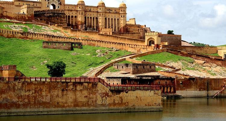 Eine große Festung mit einem Wassergraben und einer lebendigen grünen Landschaft.