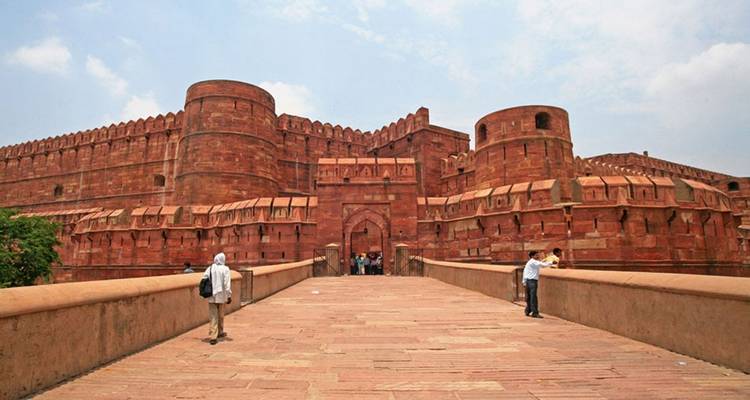Eine rote Festung mit massiven Mauern und Menschen, die in der Nähe gehen.